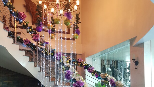 Una gran escalera adornada con un candelabro, luces y ornamentos.