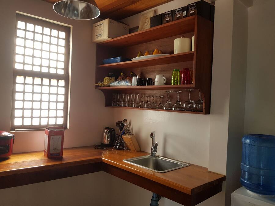 A kitchen with a wooden countertop, a sink, and a window with a grid pattern.