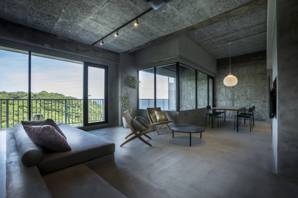 A modern interior with a large window, a sofa, a dining table, and chairs.