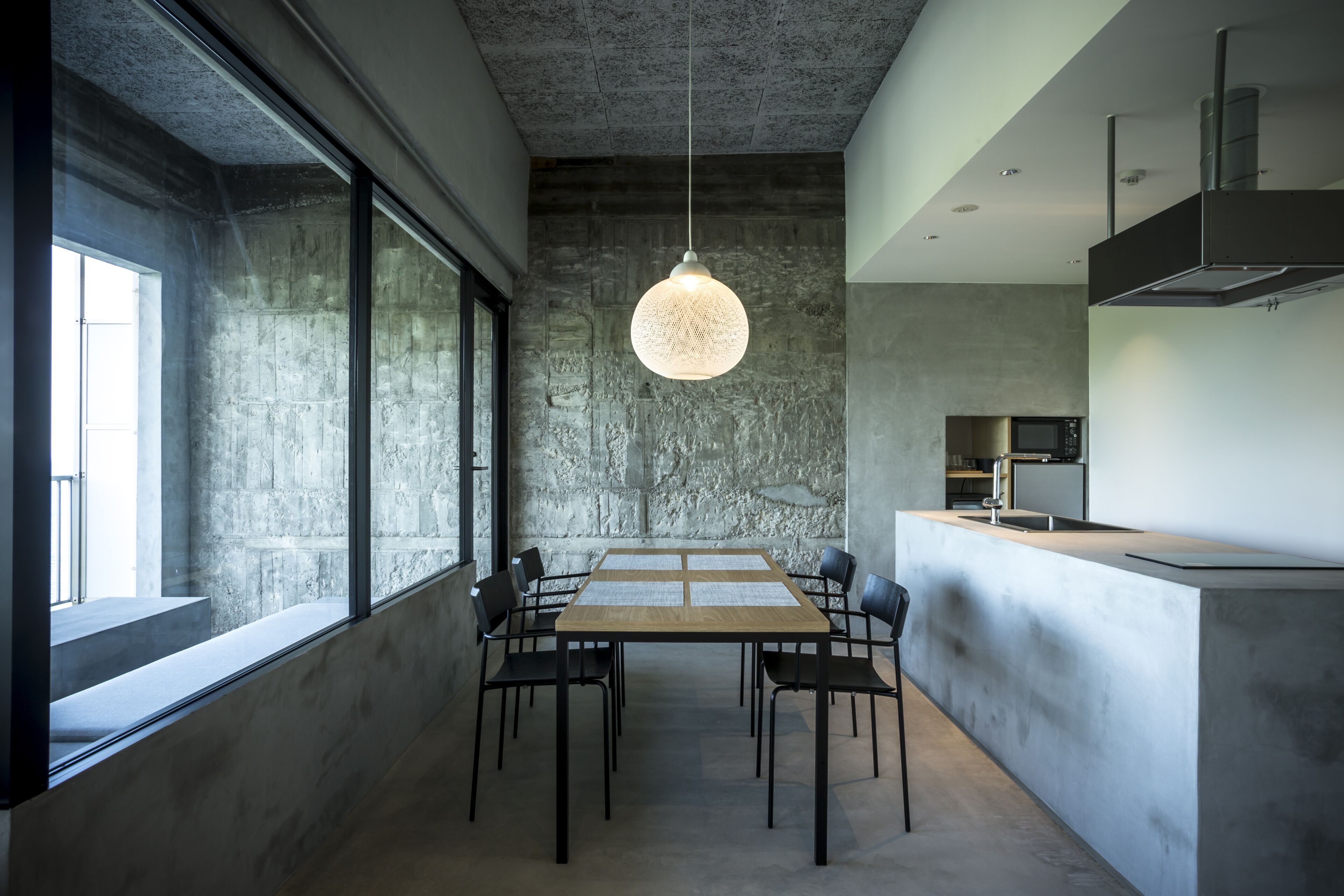 Una cocina moderna con una isla grande, una mesa de comedor con sillas e iluminación colgante.