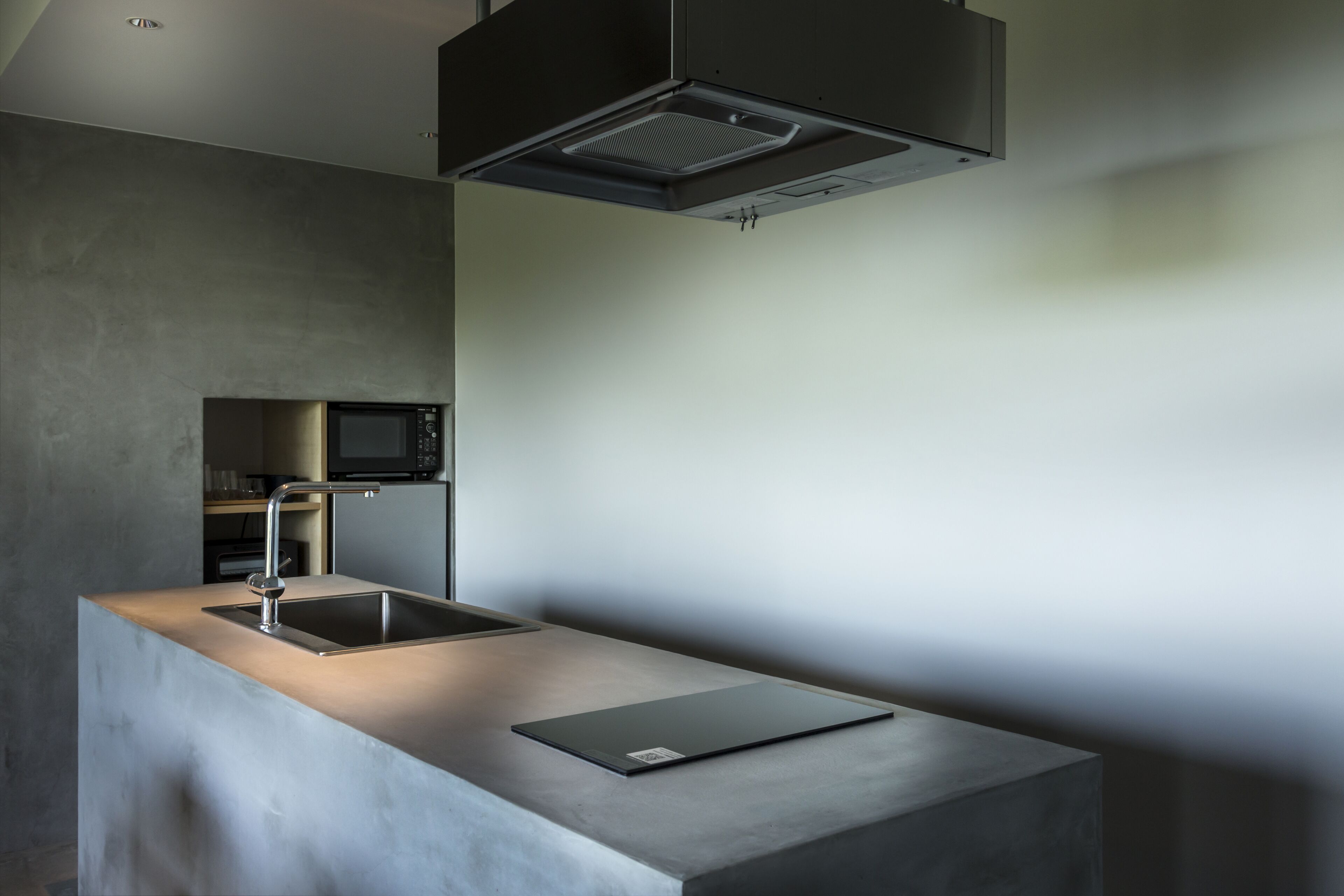 A modern kitchen with a built-in microwave, stainless steel sink, and a sleek countertop.