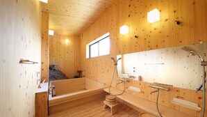Interior de madera con una bañera, ducha y ventana.