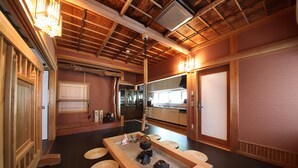 Una habitación japonesa tradicional con suelo de tatami, puerta corredera shoji y techo de madera.