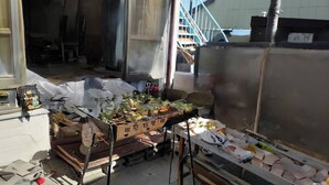 A cluttered storage area with various items, including boxes and debris, in a residential setting.