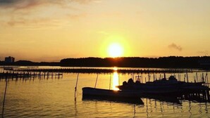 A sunset over a calm body of water with a dock and boats.