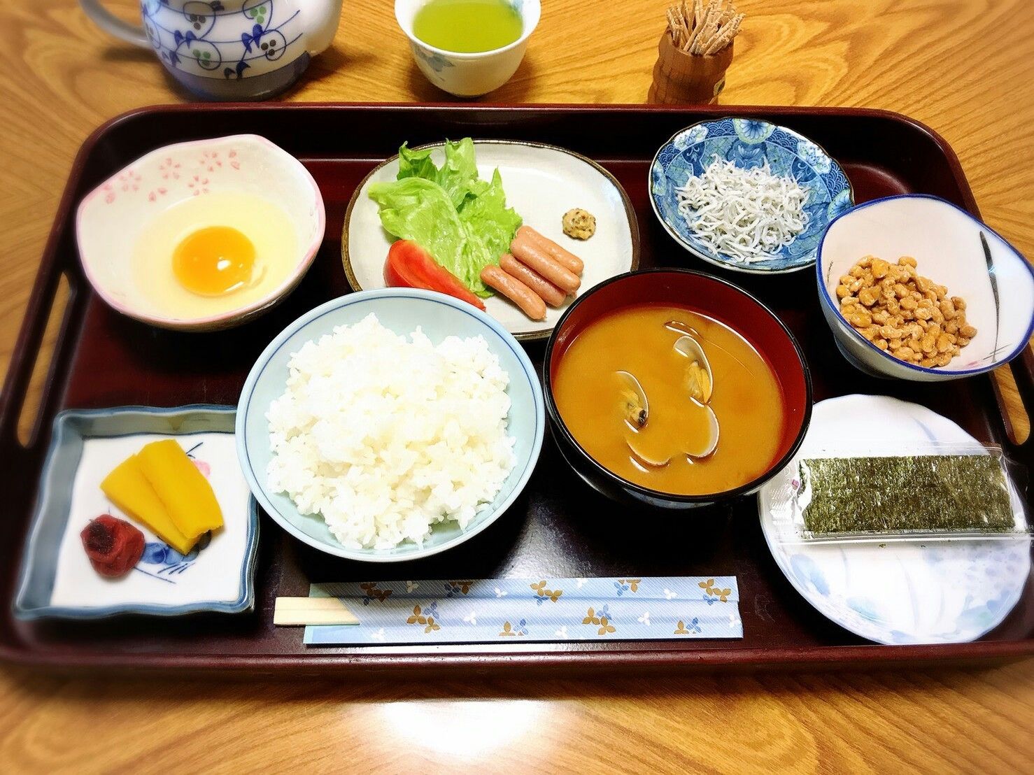 Una bandeja tradicional japonesa con diversos platos, incluyendo arroz, sopa y vegetales encurtidos.