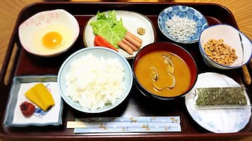 Una bandeja tradicional japonesa con diversos platos, incluyendo arroz, sopa y vegetales encurtidos.