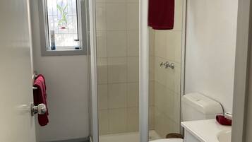 Un baño con ducha, inodoro y lavamanos.