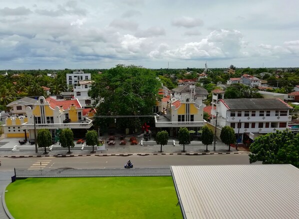 Une vue d’une ville avec des bâtiments, une pelouse verdoyante et une route.