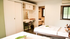 A hotel room with two beds, a desk with a chair, a mirror, and a window with blinds. - Qi Hotel and Club (Kota Kinabalu)