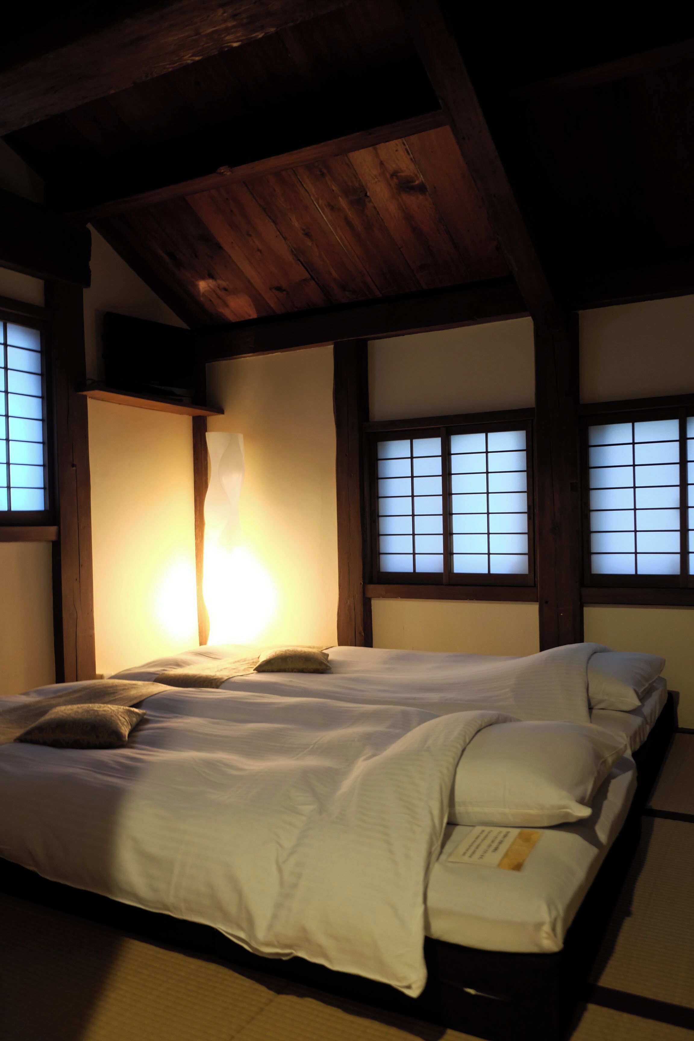 Une pièce de style japonais traditionnel, avec un sol recouvert de tatamis, un plafond bas en bois et des portes coulissantes en papier de riz (shoji).
