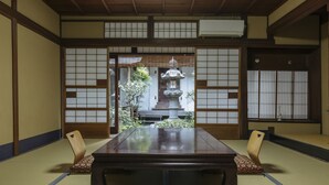 Ein traditioneller japanischer Raum mit Tatami-Böden, einem niedrigen Tisch und Shoji-Schiebetüren.