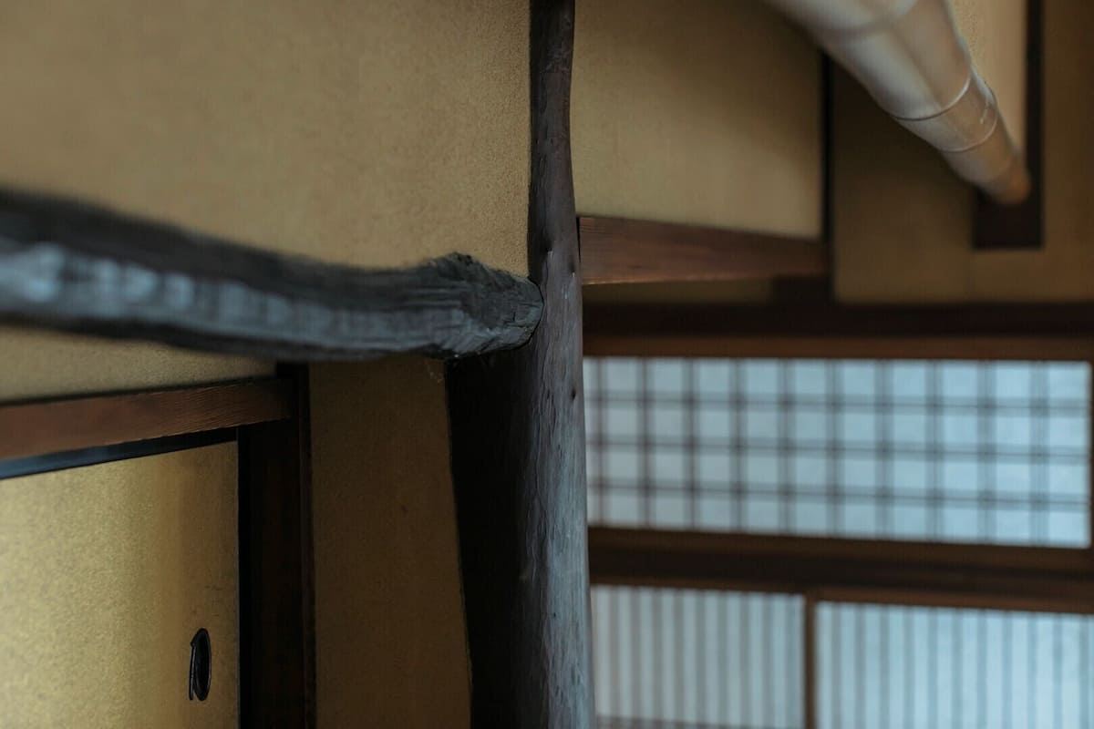 Une pièce de style japonais traditionnel, avec un sol recouvert de tatamis, un paravent en papier de riz (shoji) et une structure en poutres de bois.