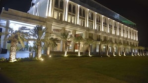 A large, illuminated building with a symmetrical facade, multiple windows, and a central entrance. - Pride Hotel & Convention Centre Indore (Indore)