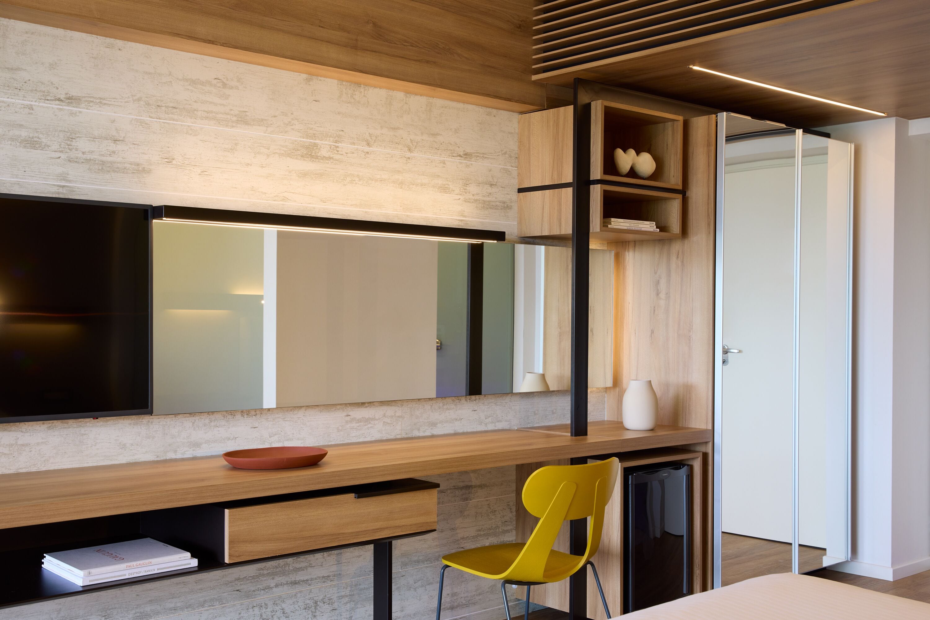 Une cuisine moderne avec un plan de travail en bois, une chaise jaune et un four encastré.