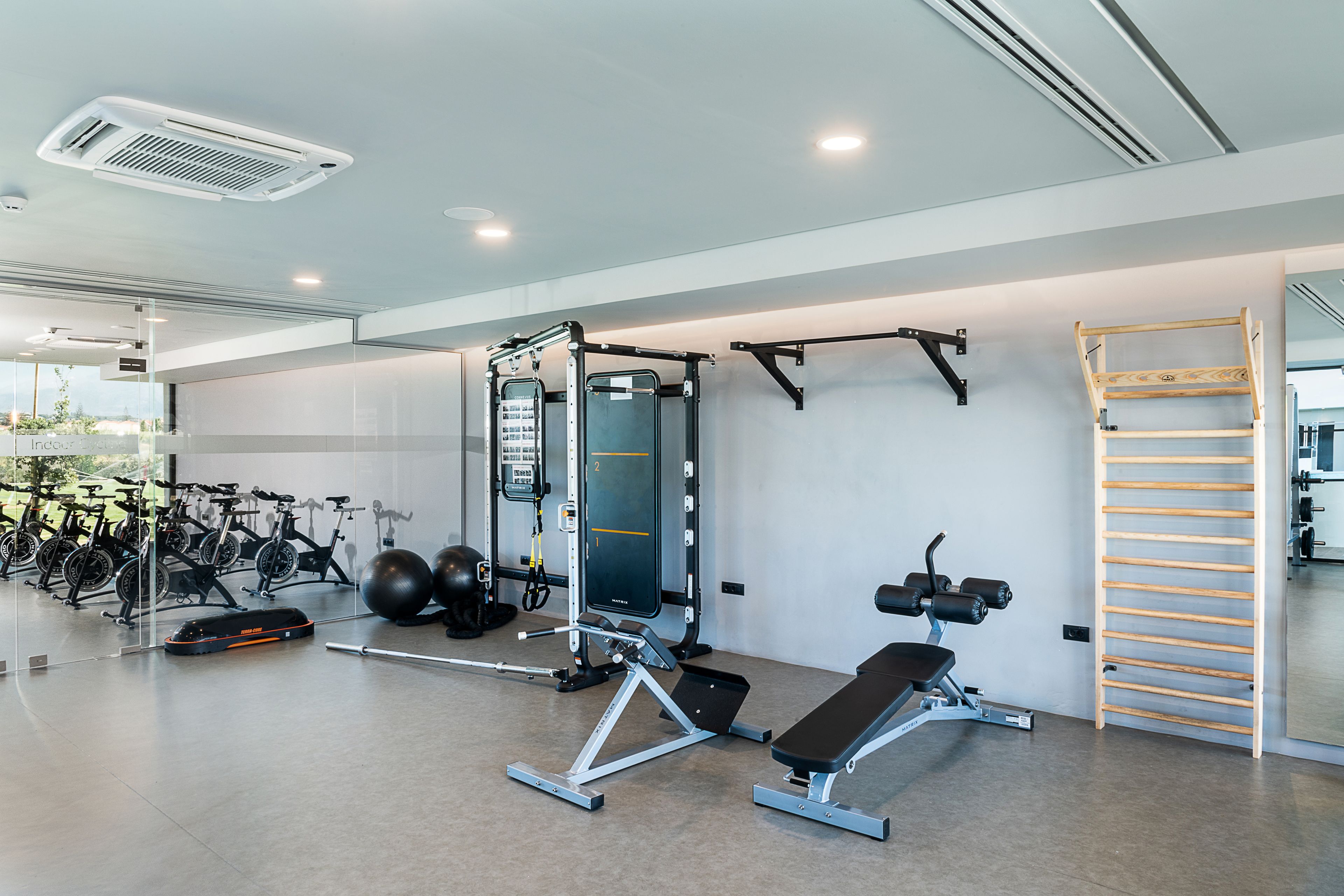 Una palestra moderna con attrezzature per esercizi, una panca e una scala in legno.