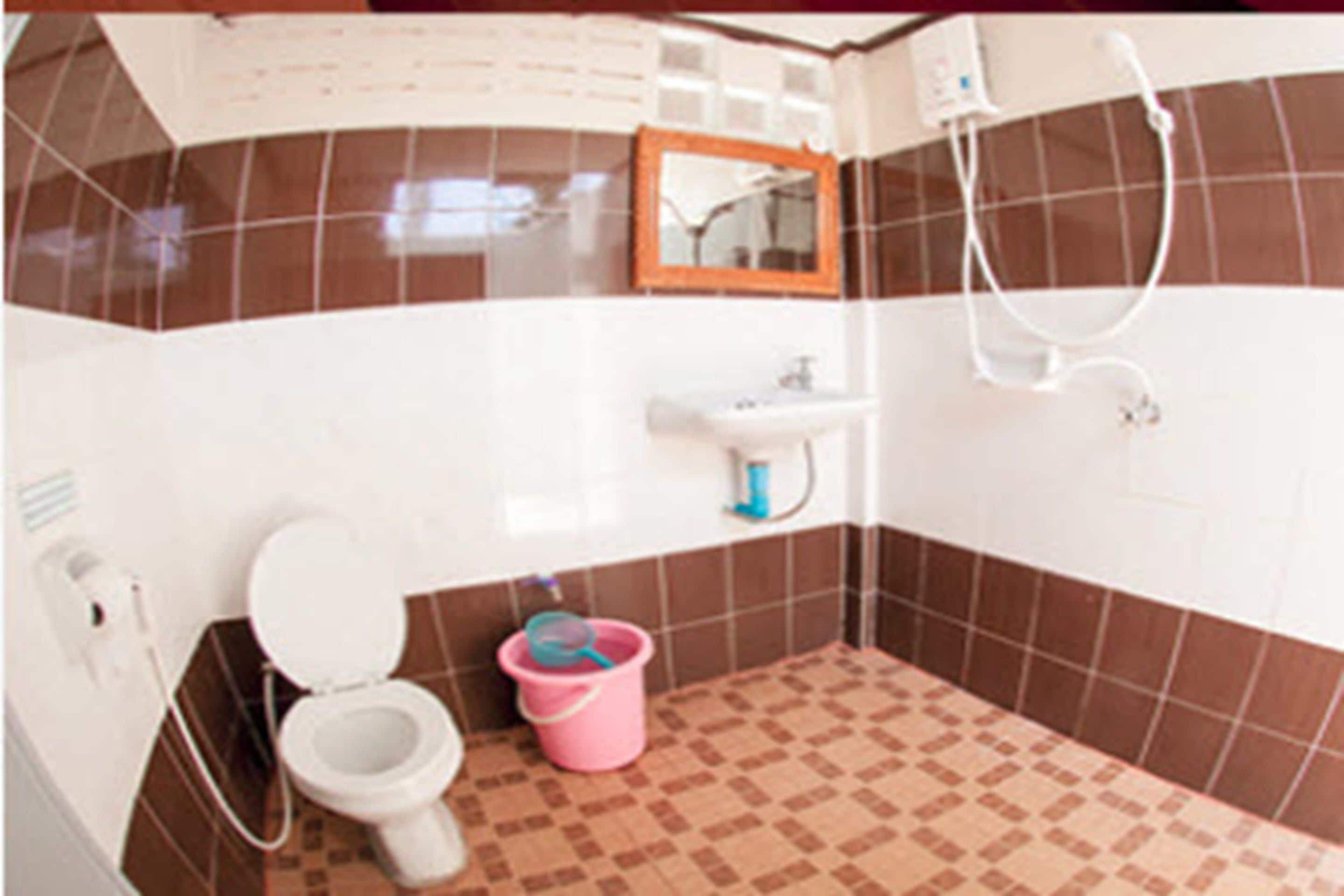 A bathroom with a toilet, sink, and shower.