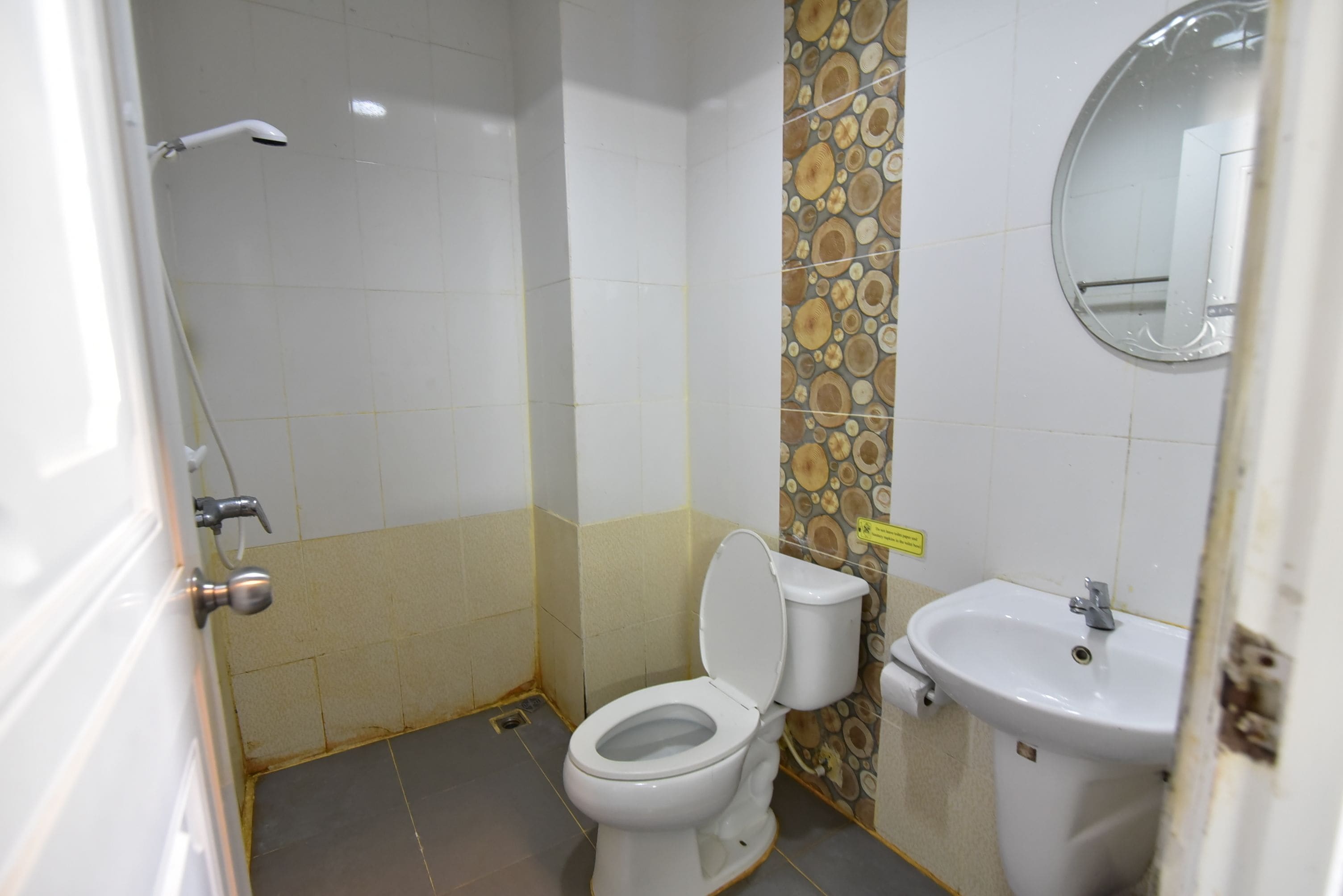 Een badkamer met toilet, wastafel en douche.