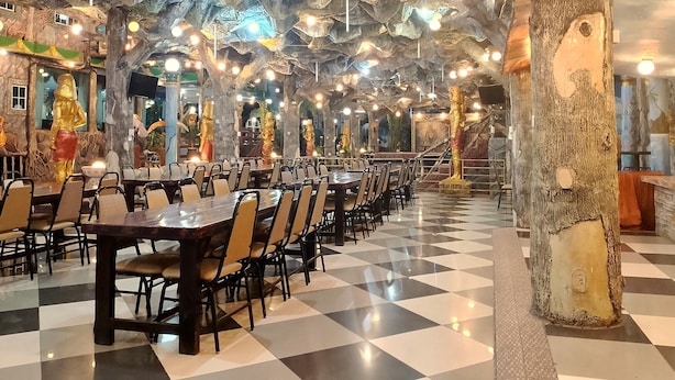 Een restaurant met een schaakbordvloer en tafels in rijen.