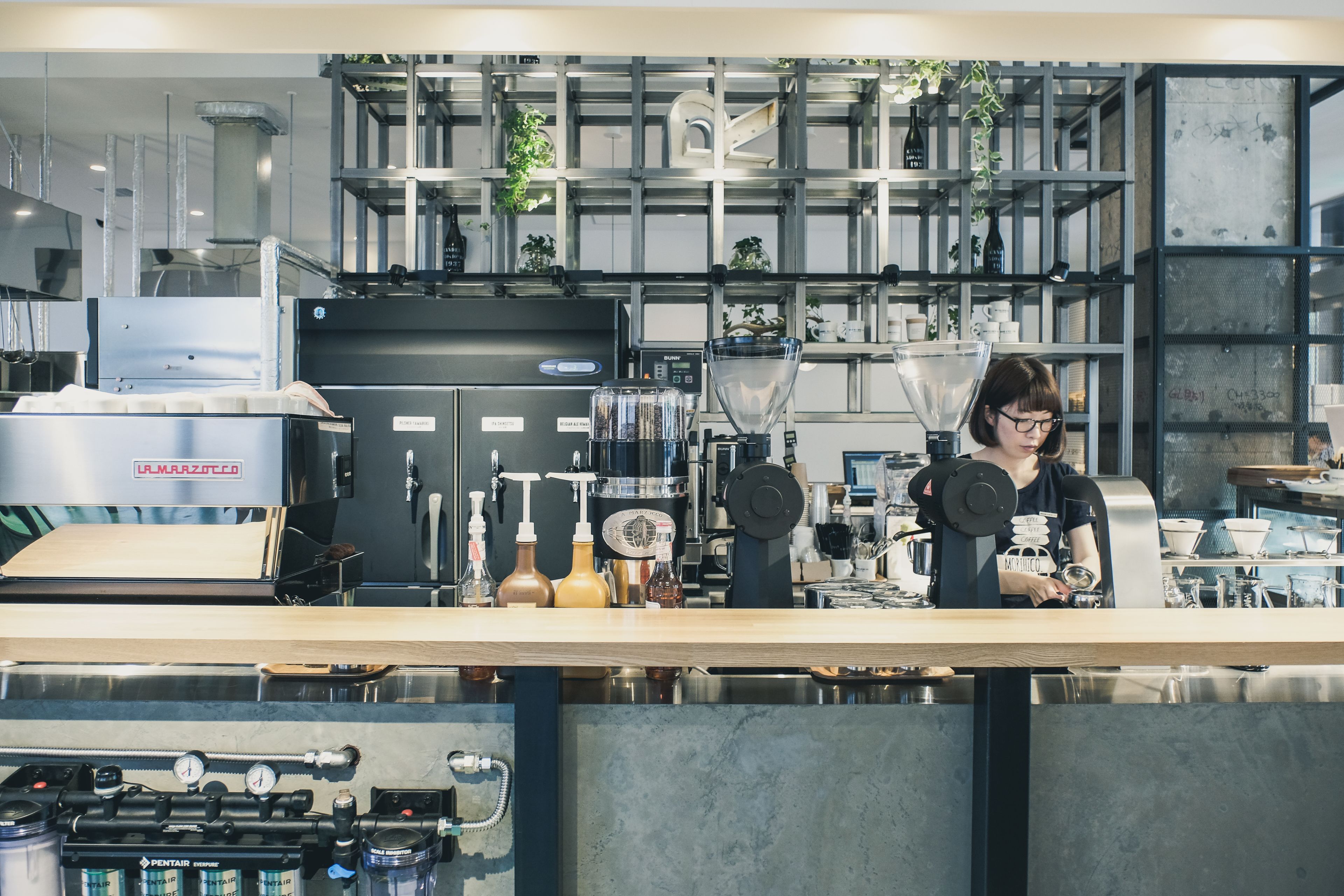 A modern coffee shop with a barista preparing drinks.