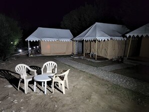 A campsite with two tents, a table, and four chairs. - Royal Deluxe Camp (Leh)