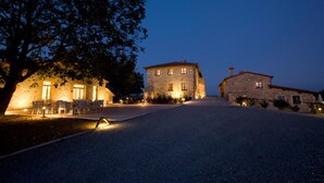A stone building with a paved driveway and outdoor seating area. - Villa Il Castagno Wine & Resort (Siena)