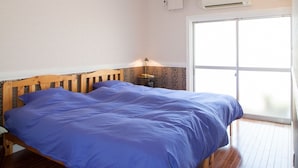 A bedroom with a wooden bed, a ceiling fan, an air conditioning unit, and a large window. - Kyoto Tenseian (Kyoto)