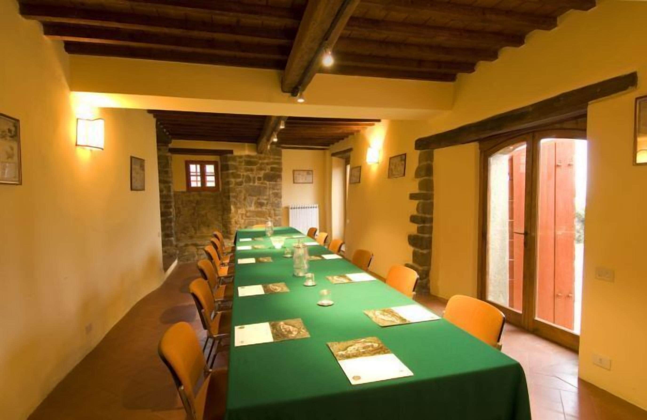 A conference room with a long table, chairs, and a stone wall.