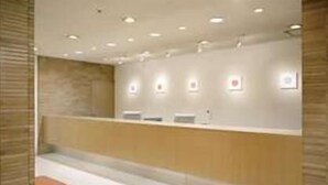 Un espace d’accueil comprenant un comptoir, un banc et un panneau d’information fixé au mur.