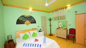 Un dormitorio con cama, escritorio, silla, armario, ventilador de techo y un cuadro en la pared.