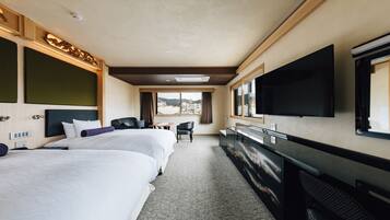 A hotel room with two beds, a desk, a TV, and a window with a city view.