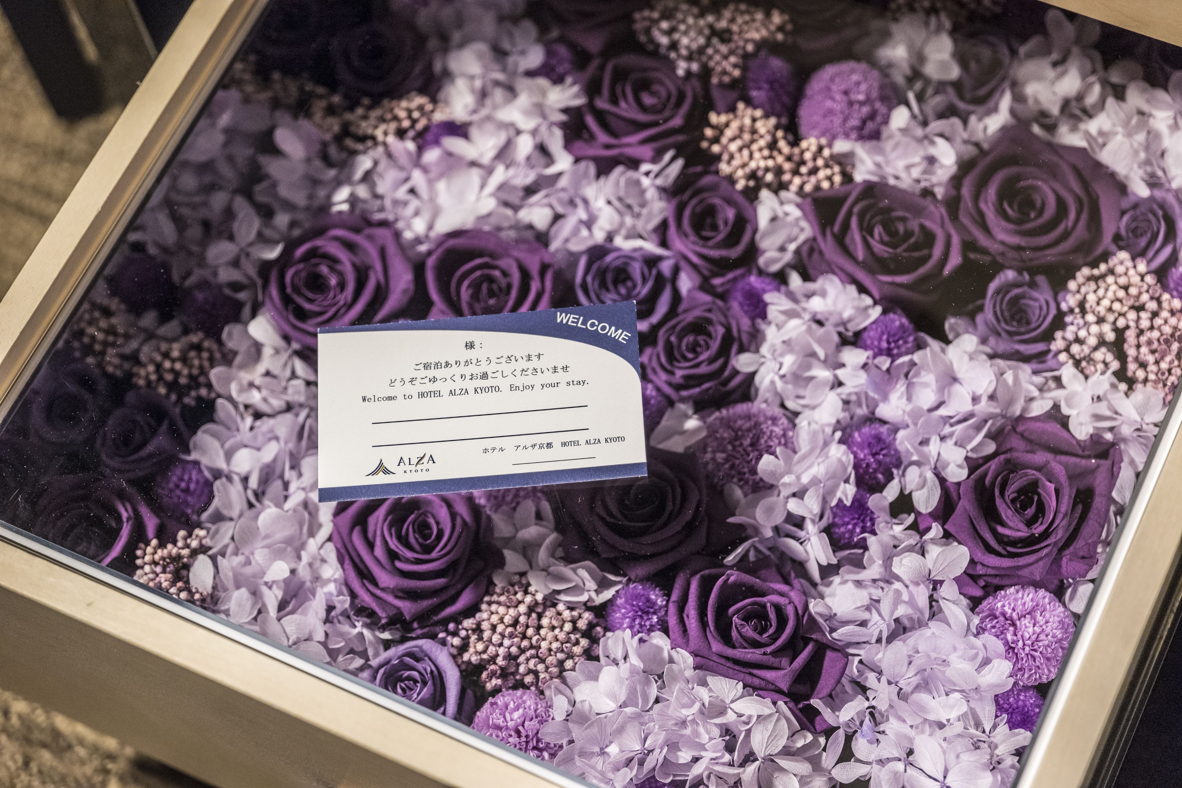 A welcome card in a floral arrangement box.