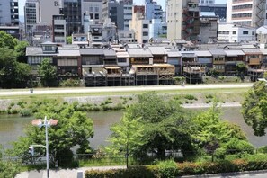 A riverside view of traditional Japanese buildings with a clear river and greenery in the foreground. - Hotel ALZA KYOTO (Kyoto)