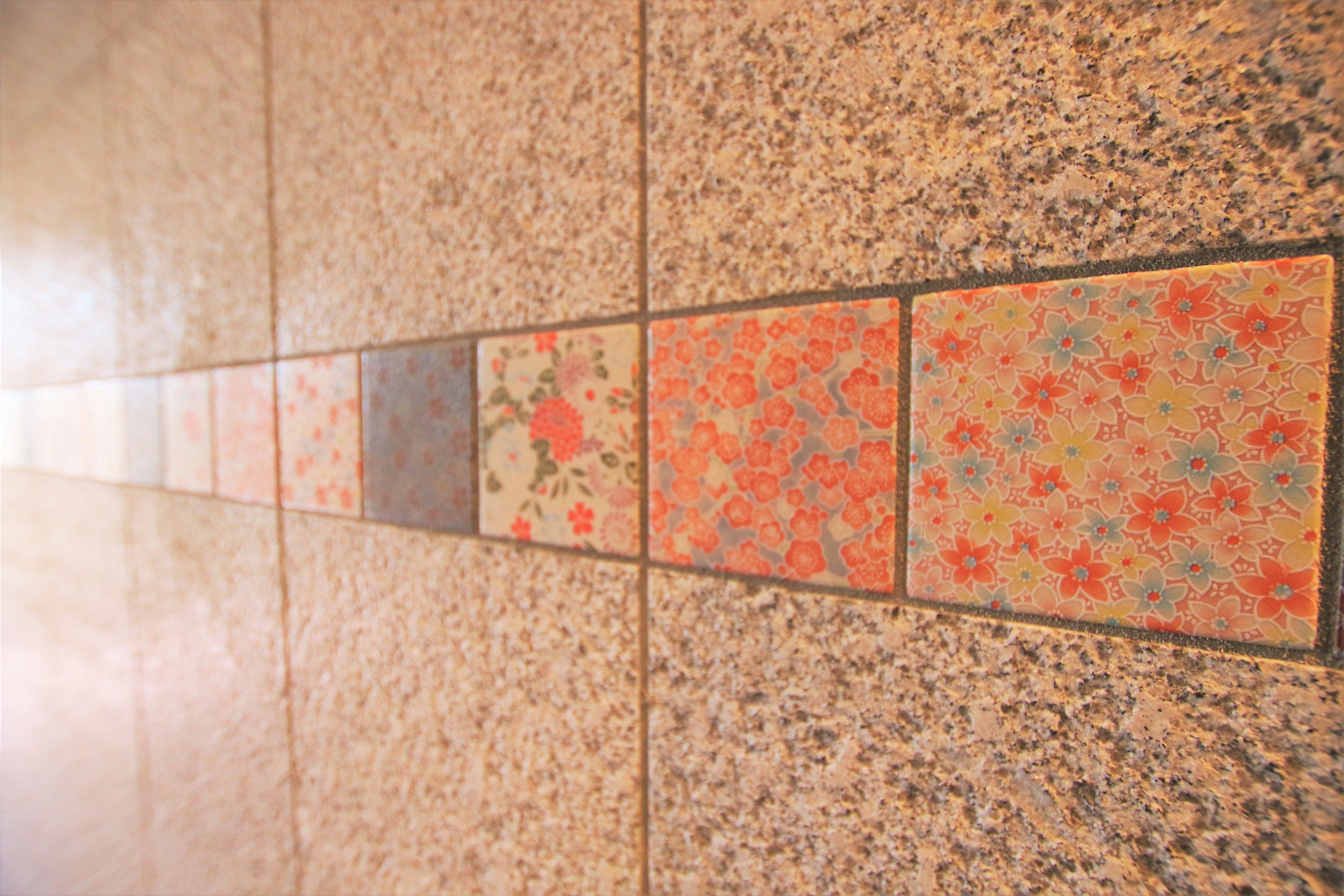 A tiled floor with a mix of plain and floral patterns.