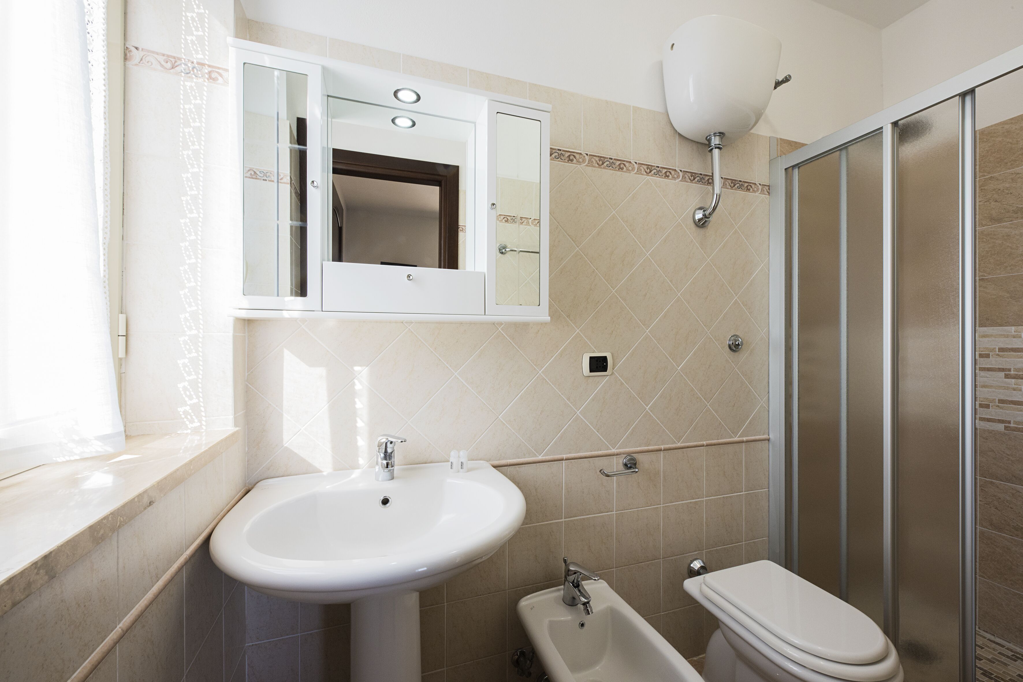 A bathroom with a sink, toilet, and shower.