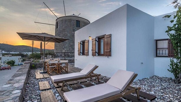 A rooftop terrace with lounge chairs, a table, and an umbrella. - The Millers House Adamas Sea View (Milos)