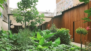 Un jardín con diversas plantas y una cerca de madera.