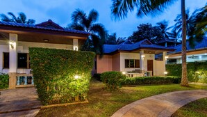 A resort with multiple buildings, well-maintained lawns, and palm trees.