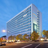 Un moderno edificio de hotel con una fachada de ventanas enrejadas y un llamativo letrero del Hotel Asahi.