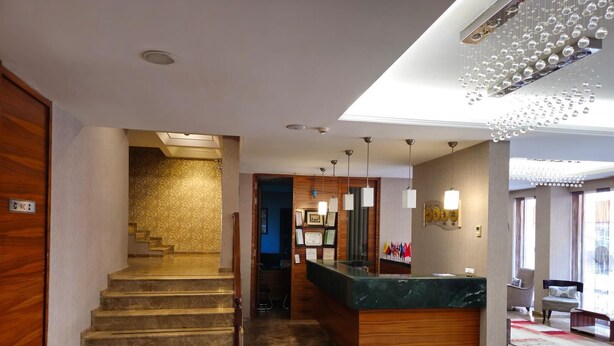 A hotel lobby with a marble staircase, a reception desk, and a modern chandelier. - Gemlik Pasa Hotel (Gemlik)