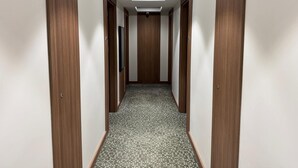 A narrow hallway with wooden doors and a patterned carpet. - Gemlik Pasa Hotel (Gemlik)