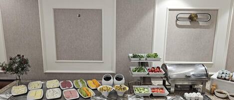 Disposição de buffet com diversos alimentos e acompanhamentos.