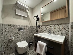 A bathroom with a toilet, sink, and mirror. - Gemlik Pasa Hotel (Gemlik)