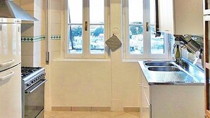 A compact kitchen with a stove, oven, and sink. - Vittorino Guest House (Rome)