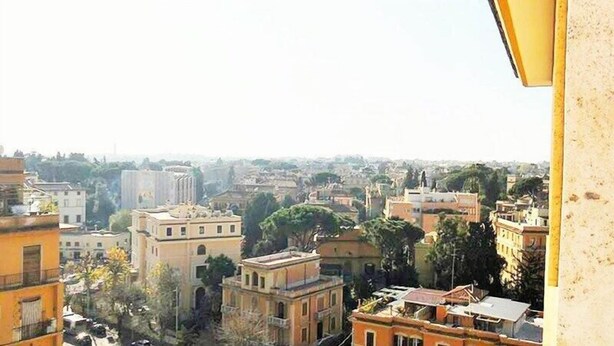 A cityscape with a mix of residential and commercial buildings, including a prominent church spire. - Vittorino Guest House (Rome)