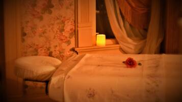 Cozy retreat with a single bed, bedside table, and comfortable chair, set against a floral wallpaper backdrop.