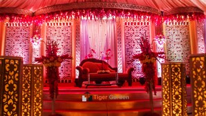 A stage with a red sofa and a piano, surrounded by ornate columns and floral decorations.