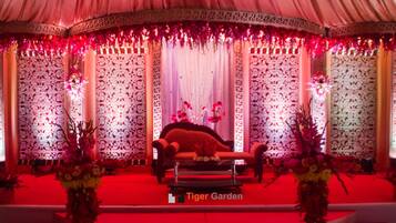 Un palco con una poltrona rossa, pannelli decorativi e composizioni floreali.
