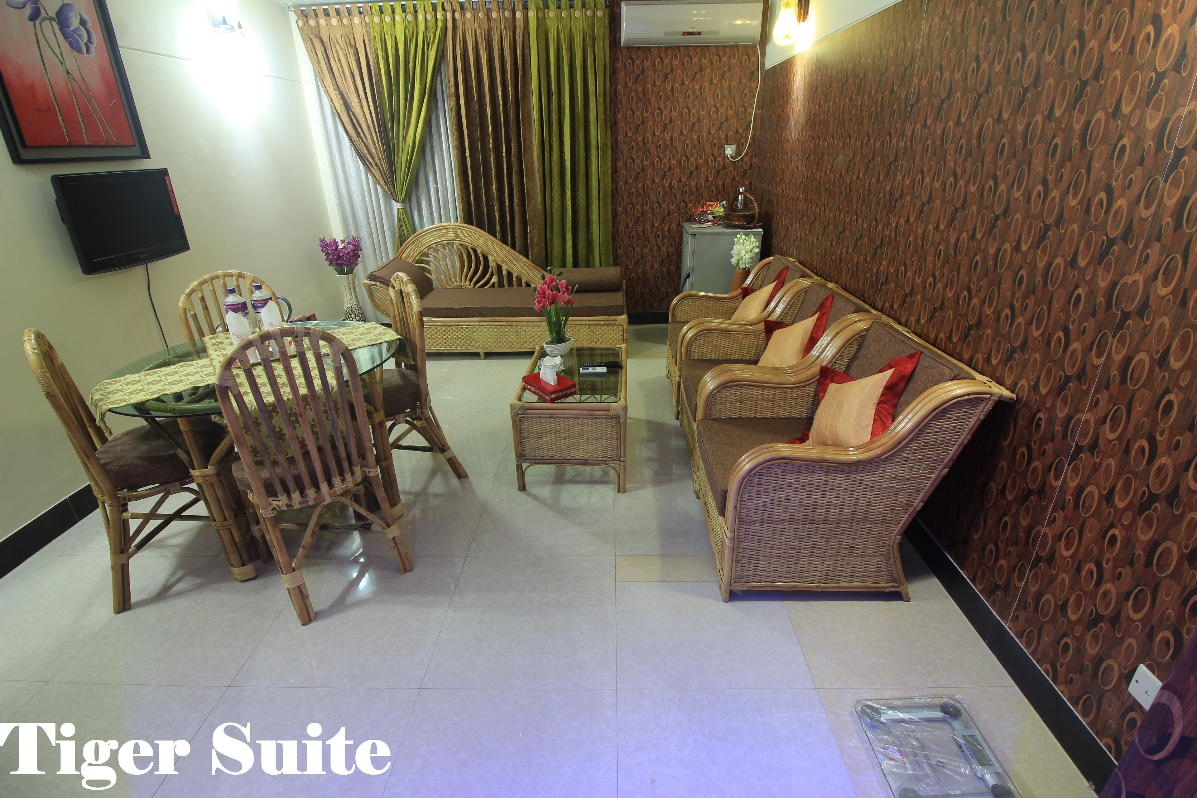 A living room with a dining table, wicker furniture, and a TV.