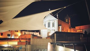 A rooftop terrace with tables and chairs, overlooking a church with a bell tower. - Peneco Albufeira GuestHouse - Hostel (Albufeira)